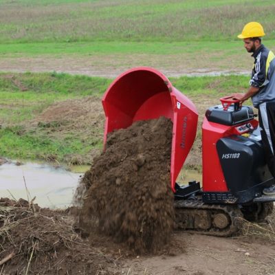 Grond kiepen naast de machine met een draaibare bak Hinowa HS1103 rupsdumper van Safety Lift.